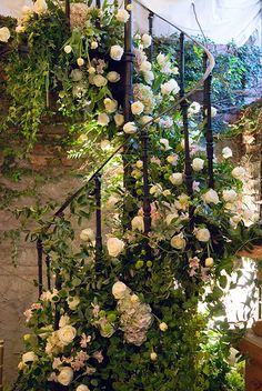 white roses and greenery are growing on the stairs