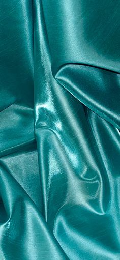 a close up view of a teal green satin fabric with very thin lines on it