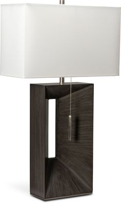 a table lamp with a white shade on it's side and a wooden structure in the shape of a cube