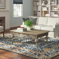 a living room filled with furniture and a fire place in front of a book shelf