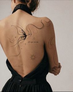 the back of a woman's body with tattoos on it