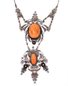 "Amazing late Victorian coral cameo and gilded silver filigree necklace. Very elaborate hand-wrought design featuring a two layered pendant that lends a charming movement to the piece. The focal point is the high relief coral cameo of a classical goddess. The lower panel features a matching coral cabochon. The swirling filigree is studded with tiny gilded silver beads. Delicate milgraining throughout adds a subtle texture. The chain is very simple and the clasp is original and works perfectly. I Elegant Carved Necklaces For Formal Occasions, Elegant Carved Necklace For Formal Occasions, Formal Orange Cabochon Necklace, Antique Carved Necklaces For Formal Occasions, Ornate Medallion Necklace With Cabochon, Oval Filigree Necklace In Art Nouveau Style, Ornate Medallion Cabochon Necklace, Art Nouveau Oval Filigree Necklace, Ornate Carved Pendant Necklace