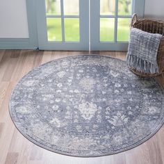 a large round rug on the floor in front of a door with a wicker basket