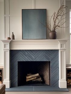 a living room with a fire place in the center and a painting on the wall