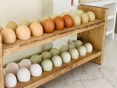 an assortment of eggs sitting on wooden shelves