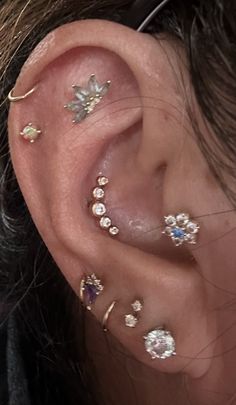 a woman with multiple ear piercings on her left side and one behind the ear