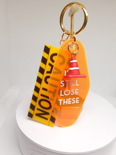 an orange and yellow keychain with a red cone on it