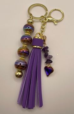 a purple tasseled keychain with lots of beads