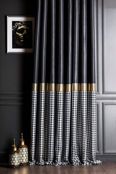 a black and white checkered curtain with gold trim on the bottom is in front of a dark gray wall