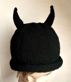 a black knit hat with horns on it