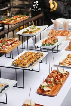 a table topped with lots of trays filled with different types of food on top of it