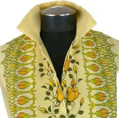 A perfect hostess dress for a spring garden dinner party. The dress features a five button front closure with an eye an hook at the top front of the collar and two button closures at each sleeve cuff. The dress is fully lined with the bottom hem trimmed in lace at the interior. Colors are lemon yellow, orange and green in a floral motif. The arms are sheer. It's a delicate, feminine beauty. Designer: Alfred Shaheen Made in USA Size is a vintage 12, but please take note of the approximate measure Spring Vintage Dress With Covered Buttons, Spring 1970s Vintage Dress For Formal Occasions, 1970s Vintage Dress For Spring Formal, 1970s Style Vintage Dress For Spring Formal, Spring Mod Dresses With Buttons, Spring Vintage Dress With Buttons For Vintage Fashion, Spring Vintage Silk Dress, Vintage Dress With Button Closure For Spring, Spring Vintage Dress With Button Closure