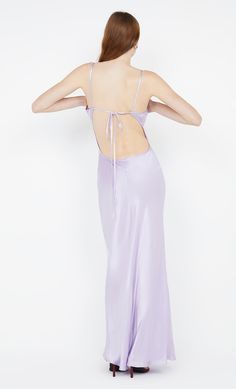 the back of a woman wearing a lavender colored dress with spaghetti straps and an open back