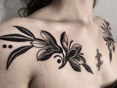 a woman's chest with black flowers and dots on the left side of her body