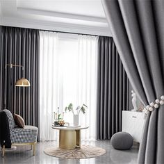 a living room filled with furniture next to a window covered in grey drapes and curtains