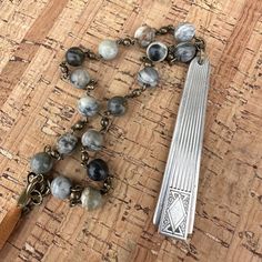 a wooden table topped with a rosary and a metal object on it's side