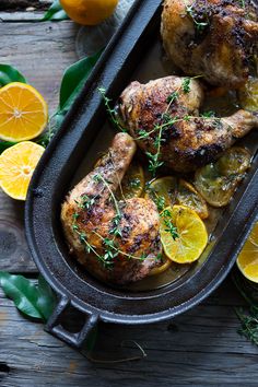 chicken with lemons and herbs in a cast iron pan