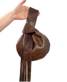 A beautiful Japanese knot bag made of the highest quality dark brown distressed colored leather. The strap is accented with striking leather fringe. The bag measures 11 inches in width by 8 inches in height. Brown Bucket Bag With Tassels For Everyday, Bohemian Brown Bucket Bag With Tassels, Brown Tassel Hobo Tote Bag, Japanese Handbags, Japanese Handbag, Japanese Knot, Purse Design, Leather Fringe Bag, Japanese Knot Bag