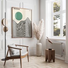 a room with white walls and wood flooring has a large painting on the wall