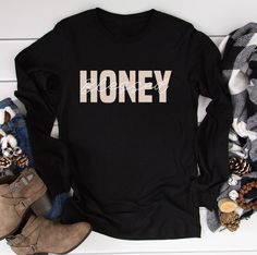 "Blessed Honey T-Shirt, Honey long sleeve shirt, Honey Life T-Shirt,Mother's Day Gift, Cute Honey Tee, Grandma Gift for the Holiday Christmas HOW TO ORDER 1. Select the shirt \"Style and Size\" 2.Select the shirt Color 3. Enter what would you like to say on your t shirt and LETTERING color 4.Select the quantity. 5. Click Add to cart.       If you have any difficulties, send us a message. Processing Time and Shipping The standard processing time is 1-3 business days. We usually proses and ship out the orders the next business day.   USA Orders: Standard : Takes 3 to 5 days to get delivered Priority : Takes 2 to 4 days to get delivered Express: Takes 1 to 2 days to get delivered   METERIALES High Quality Heat Transfer Vinyl, Unisex Shirt DESCRIPTION Please see the sizing chart for choosing y Long Sleeve T-shirt With Lettering, Winter Long Sleeve Tops With Lettering, Black Long Sleeve Top As Gift, Black Long Sleeve Top As A Gift, Long Sleeve Text Print T-shirt For Winter, Long Sleeve Tops With Graphic Print, Long Sleeve Graphic Tee T-shirt As Gift, Long Sleeve T-shirt With Text Print For Gift, Text Print Long Sleeve T-shirt For Gifts