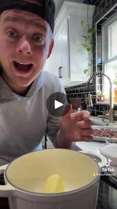 a man making food in the kitchen with his mouth wide open and looking surprised at the camera