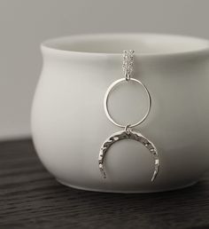 Adorn yourself with this remarkable sterling silver Two Cups Circle and Hammered Crescent Moon Necklace. This beautiful piece of jewelry has a minimalist style that is sure to make you feel like a goddess. The multifaceted symbolism of the full and half moon pendants is perfect for connecting to your spirituality. Make a statement with this elegant and timeless piece. Upside down Moon Necklace Sterling Silver Good Luck Zen Pagan Celestial Pendant Jewelry Gift for her Celestial Jewelry, Lunar Cha Hypoallergenic Sterling Silver Crescent Jewelry, Hypoallergenic Crescent Sterling Silver Jewelry, Everyday Hypoallergenic Moon-shaped Jewelry, Everyday Hypoallergenic Moon Shaped Jewelry, Minimalist Crescent Sterling Silver Jewelry, Minimalist Sterling Silver Moon Necklace, Minimalist Crescent Hammered Jewelry, Minimalist Hammered Crescent Jewelry, Minimalist Silver Jewelry With Moon Phase