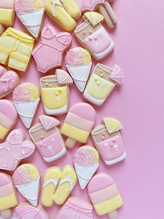 some cookies that are sitting on a pink tablecloth and one is decorated in pastel colors