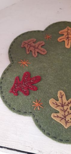 a close up of a piece of felt with leaves and stars on the top of it