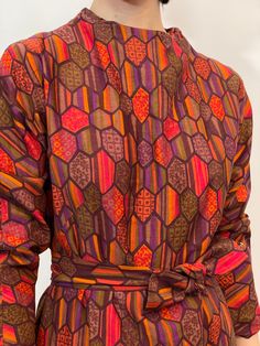 60s geometric printed long sleeve shift dress with red, green, maroon, purple, and orange, two pockets, comes w/ a belt to fit to your waist, metal zipper in the back, cotton (?). measurements taken while lying flat, double for circumference. Size S/M, Shoulders 16", waist 19.5", hips 23.5", length 40", sleeves 21", zipper 10", belt 40". good vintage condition.  Etsy Shipping Please read -Vintage and pre-owned items may have signs of wear and use and are offered as is. Traces of age and use are therefore completely normal and do not constitute defects. Please see pictures as they are part of the item description and refer to sizes/measurements provided. measurements are taken Flat, double for circumference. Please contact me if you want more information and/or pictures.  All sales are fina Long Sleeve Multicolor Dress With Geometric Pattern, Multicolor Long Sleeve Dress With Geometric Pattern, Multicolor Long Sleeve Dress With Vintage Print, Multicolor Long Sleeve Dresses With Vintage Print, Belted Multicolor Dresses For Fall, Colorful Long Sleeve Dress For Fall, Red Long Sleeve Dress With Colorful Pattern, Patterned Long Sleeve Dresses For Fall, Patterned Long Sleeve Fall Dresses