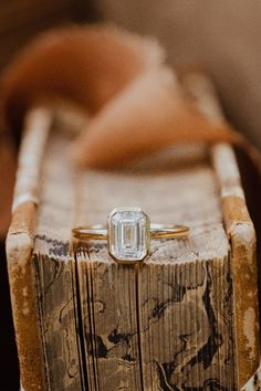 an engagement ring sitting on top of a wooden box