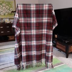 a plaid blanket draped over a tv in a living room