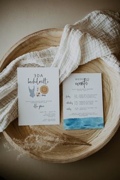 two wedding cards sitting on top of a wooden plate