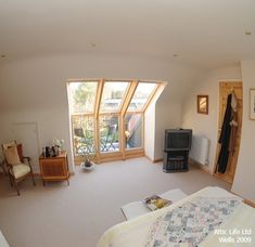 a bedroom with a bed, dresser and television in it's center room area