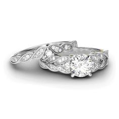 two white gold wedding rings with diamonds on each side and an intricate design in the middle