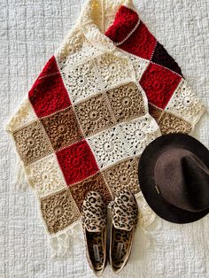 a hat, scarf and pair of leopard print slippers are laid out on a bed