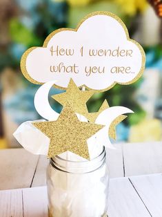 a mason jar filled with gold glitter stars and a sign that says, how i wonder what you are