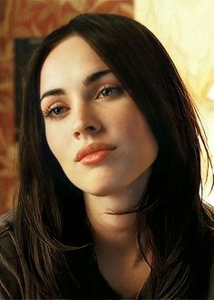 a woman with long dark hair wearing a brown shirt and looking off into the distance