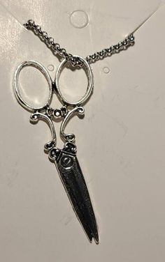 a pair of scissors hanging from a chain