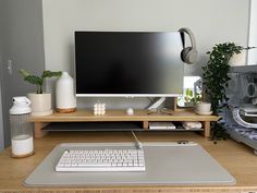 a computer monitor sitting on top of a wooden desk next to a keyboard and mouse