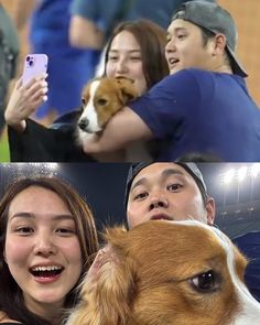 two people are taking pictures with their dogs and one is holding a cell phone in front of them