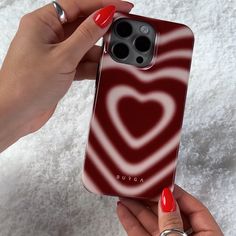 a woman's hand holding an iphone case with a red heart design on it