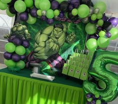 the hulk birthday party table is set up with balloons and decorations