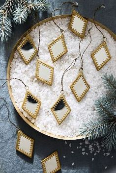 a platter filled with white and gold decorated cookies on top of snow covered ground