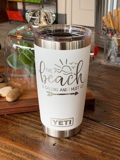 a stainless steel yeti cup sitting on top of a wooden table