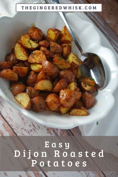 a white bowl filled with cooked potatoes on top of a wooden table next to a spoon