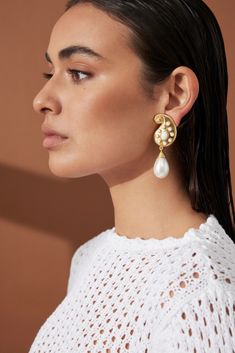 Designed with opulence in mind, these 'Anya' earrings from VALÉRE are sure to turn heads. Crafted from 24k gold plated brass in a unique design and embellished white stones and a pearl drop. Style it with your favourite little black dress. 24k Gold micron plated brass Clip with rubber stop Nickel, lead and cadmium free Handmade finish Original VALÉRE design featuring a branded stamp Measurements: Dimensions: 66.60x22mmWeight: 40g White Gold-plated Pierced Pearl Earrings, White Gold Plated Pierced Pearl Earrings, Evening Teardrop Earrings With Pearl Charm, Luxury Pearl Charm Earrings For Evening, Gold Plated Clip-on Pearl Drop Earrings, Luxury Evening Earrings With Pearl Charm, Luxury White Pearl Gold-plated Earrings, Luxury Gold Plated White Pearl Earrings, Luxury White Gold Plated Pearl Earrings