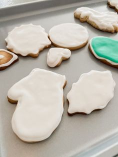 some cookies that are sitting on a cookie sheet and one is frosted with icing