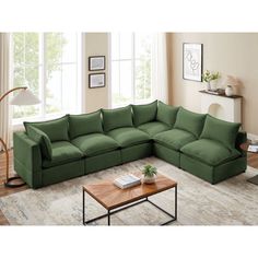 a living room with a large green sectional couch and coffee table in front of it