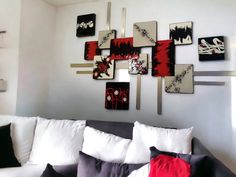 a living room filled with lots of white furniture and paintings on the wall above it