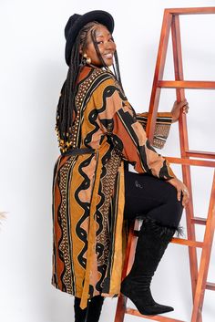 Embrace the timeless elegance of our handcrafted Bogolan kimono, made from traditional African fabric. This standard-size kimono offers both comfort and style with its unique patterns and natural dyes. Lightly structured yet flowing, it is perfect for any occasion, whether you're dressing casually or looking to make a statement. Each piece is a true homage to Malian craftsmanship, making your outfit as unique as you are. Wear a piece of African history and culture while staying effortlessly stylish. Bohemian Brown Kimono For Fall, Bohemian Brown Long Sleeve Kimono, Bohemian Long Sleeve Brown Kimono, Traditional Brown Kimono For Fall, Brown Kimono With Kimono Sleeves For Fall, Brown Long Kimono For Festival, Long Brown Kimono For Festival, Traditional Brown Kimono For Festival, Traditional Shawl Kimono For Fall